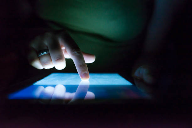 istock Closeup of female hand using tablet at night on bed. 901977806