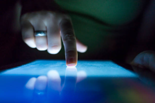 istock Closeup of female hand using tablet at night on bed. 901977860