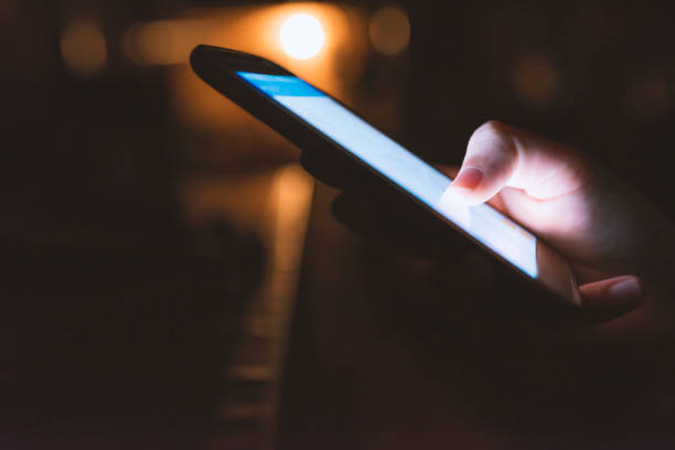 istock Woman hand hold and touch screen tablet on abstract blurred night light background. 901977920