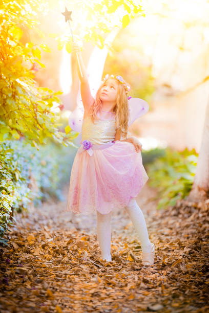 istock Little fairy with magic wand looking upwards 901983610