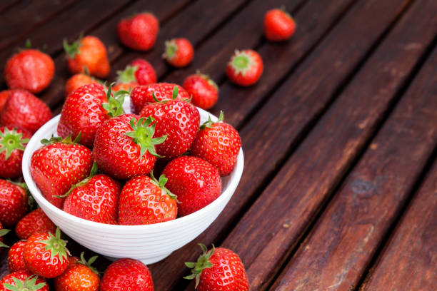 istock Strawberry in bowl on wooden table. Copy space 901983712