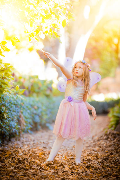 istock Little fairy with magic wand looking upwards 901983816
