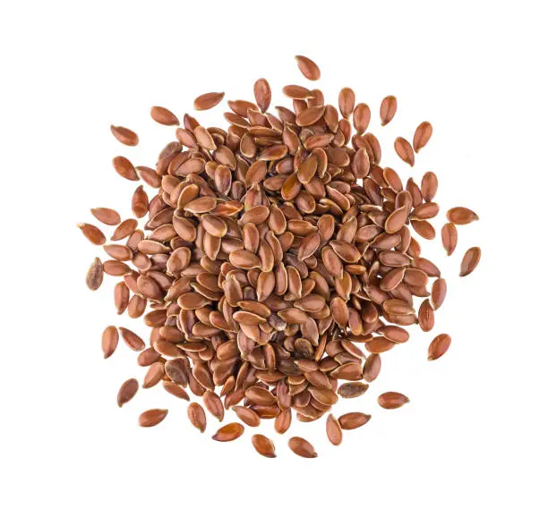 Pile of flax seeds isolated on white background close-up, top view