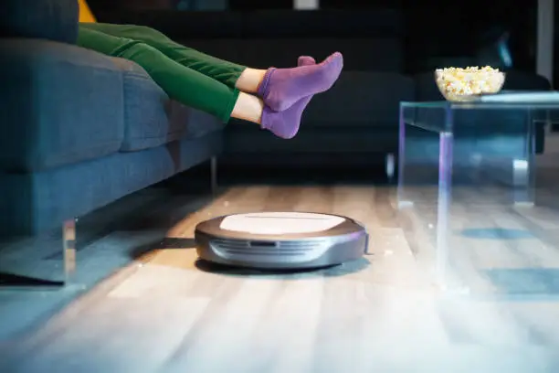 Photo of Robot Cleaning Floor While Child Watches TV Movie