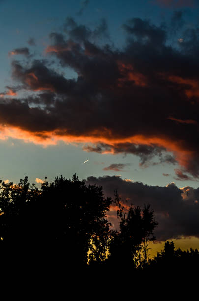 istock Dramatic cloudscape scene at orange sunset, colored sun lights on the blue sky, fluffy clouds 901992554