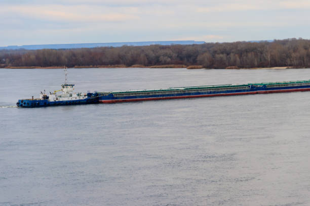 istock Tugboat pushing a heavy long barge on the river Dnieper 901995262