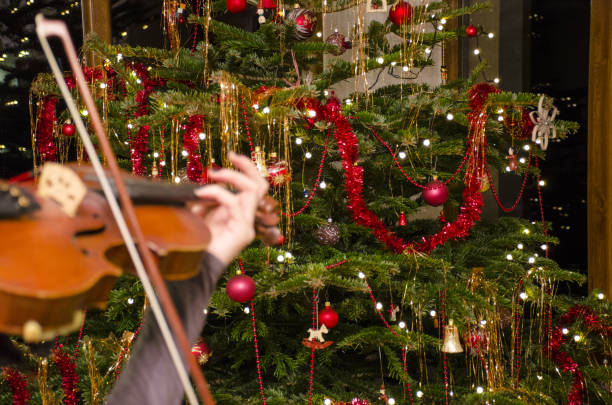 istock The blurred violin front of a Christmas tree with decoration and lights. 902006070