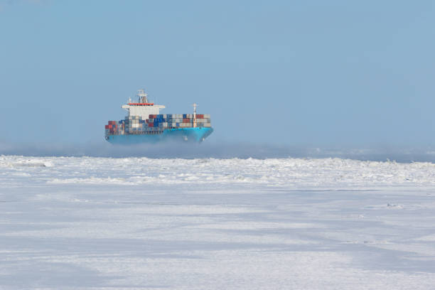 Container ship on icy waters Large cargo filled with containers navigating through ice surrounded passage arctic ocean photos stock pictures, royalty-free photos & images