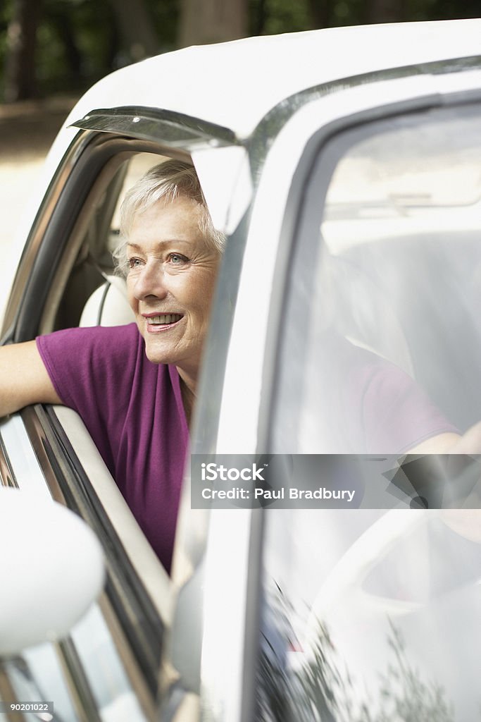 Senior donna seduta in auto - Foto stock royalty-free di Guidare