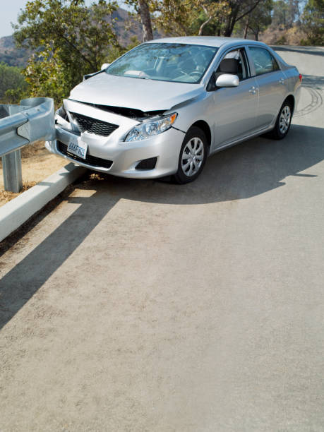 wrecked car on road guardrail - damaged car fotografías e imágenes de stock