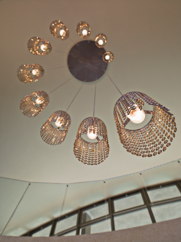 A low angle shot of a crystal chandelier hanging on a ceiling in a room