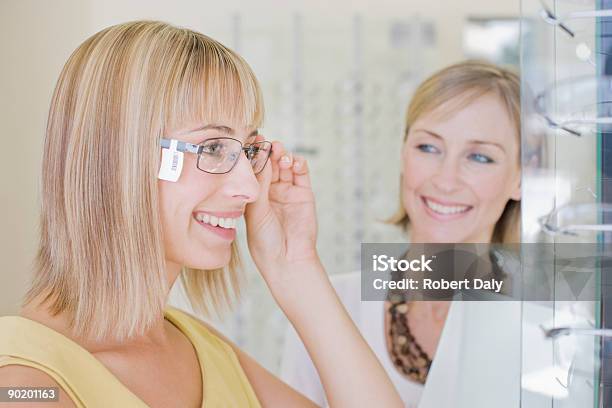 Donna Cercando Su Occhiali In Negozio Optometristi - Fotografie stock e altre immagini di Occhiali da vista - Occhiali da vista, Prezzo - Messaggio, Ottico