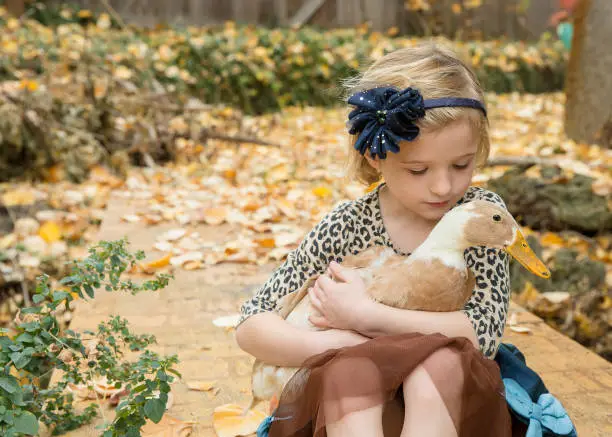 Young girl embracing her feathered friend
