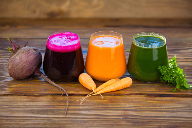 jugos de vegetales tres en copa de cristal sobre fondo de madera - bebida vegetal fotografías e imágenes de stock
