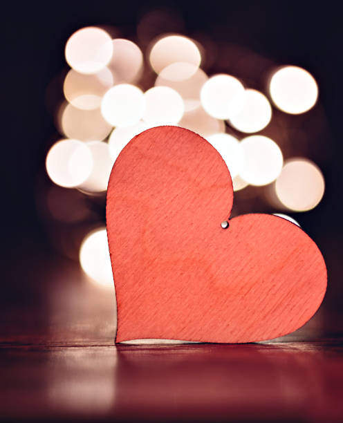 istock Plywood heart with christmas lights on a table 902021482