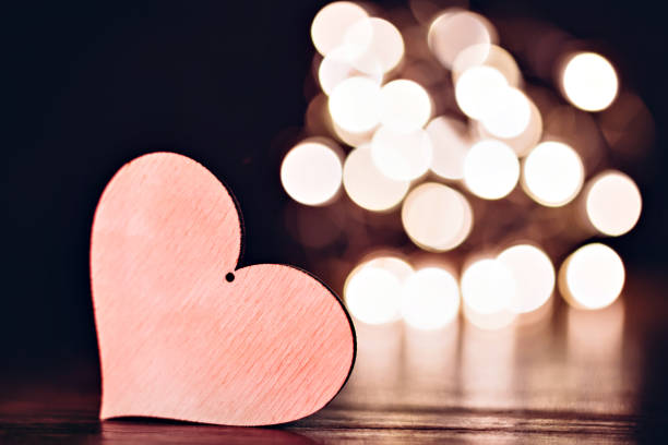 istock Plywood heart with christmas lights on a table 902021518