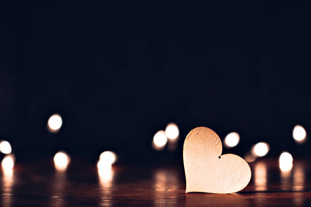 istock Plywood heart with christmas lights on a table 902021610
