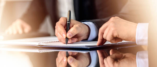 Hands signing document Close up of hands of a businessman signing contract. corporate boardroom stock pictures, royalty-free photos & images
