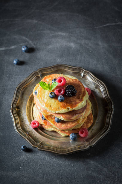 istock American pancakes with maple syrup and berries on dark table 902027508
