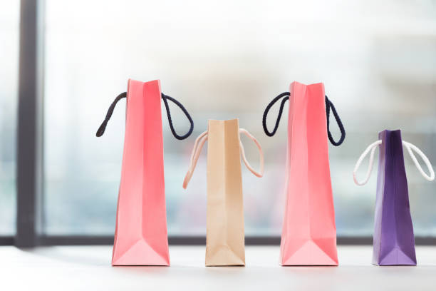 istock colored paper bags laying in a row on surface 902027666