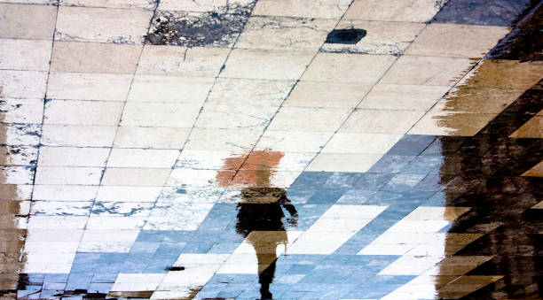 istock Reflection shadow silhouette of one man under red umbrella 902035076