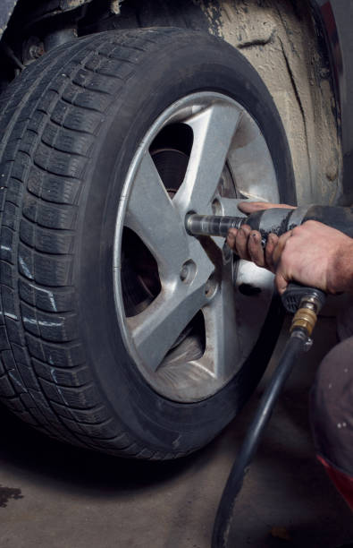 istock Professional car mechanic working with pneumatic wrench in auto service 902035766
