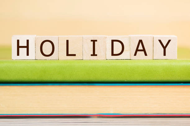 istock Holiday word built with letter cubes on green book 902048280