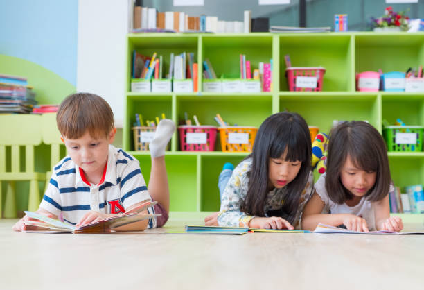 istock diversity kid lay down on floor and reading tale book in preschool library,Kindergarten school education concept 902063026