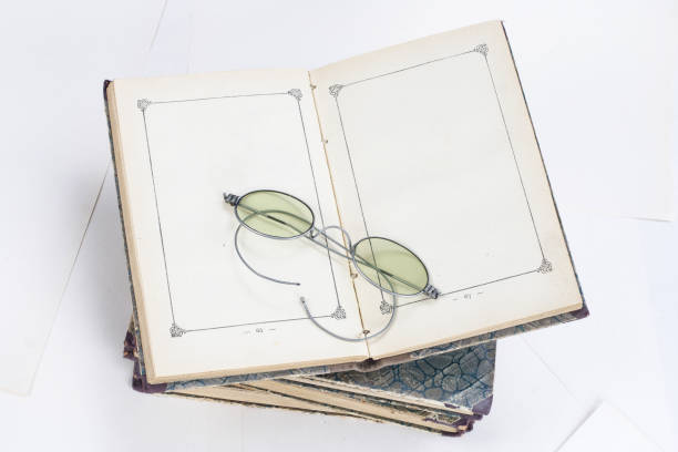 istock Old books with eye-glasses isolated on white background 902077306