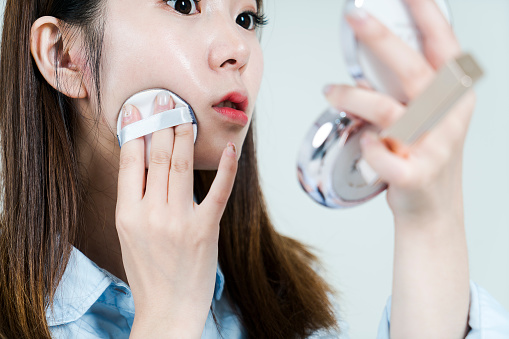 disparo de estudio de joven empresaria asiática aplicar maquillaje photo