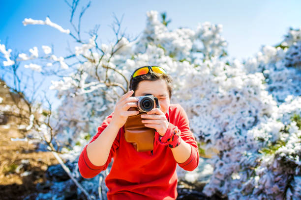 The tourist was on the hilltop in winter.