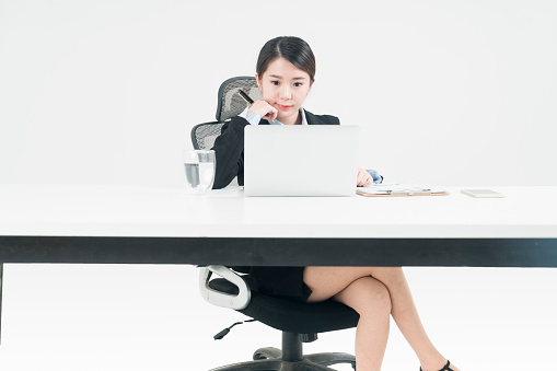 asian business woman working at desk against white background.