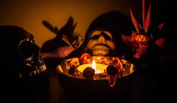 Photo of scary shaman ritual figures around a candle at night