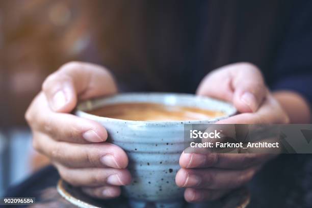 Closeup Image Of Hands Holding A Cup Of Hot Coffee On Glass Table In Cafe Stock Photo - Download Image Now