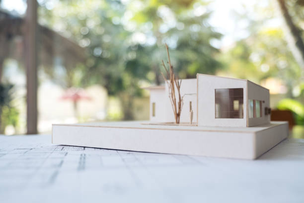 istock An architecture model with shop drawing paper and laptop on table in office with blur nature background 902096762