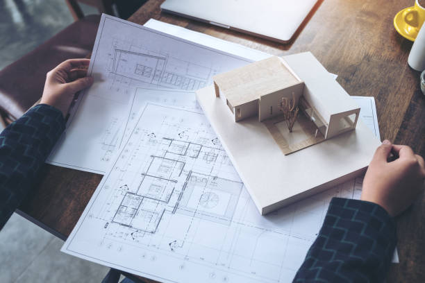 istock An architect working and looking at an architecture model with shop drawing paper on table 902096822