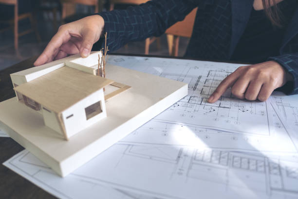 istock An architect working and pointing at architecture model with shop drawing paper on table 902096868