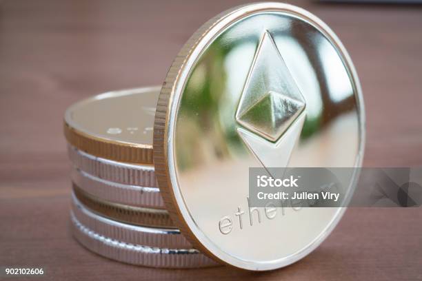 Pile Of Coin Of Silver Ethereum On Wooden Background Stock Photo - Download Image Now