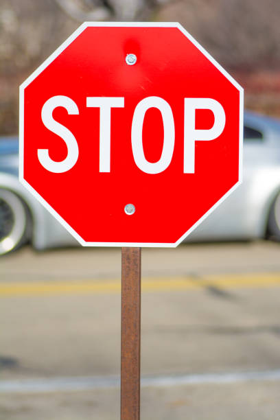 istock Stop Sign in Front of Car 902102898