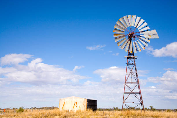 Windmill in Queensland, Australia, with blue sky and fluffy white clouds