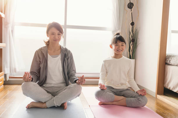 istock Mother and daughter stretching at home 902136948
