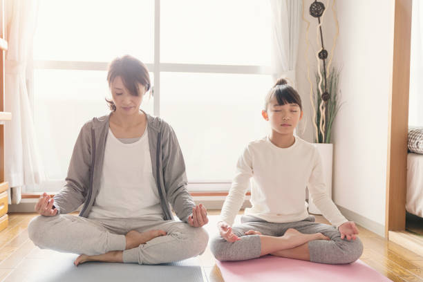 istock Mother and daughter stretching at home 902136982