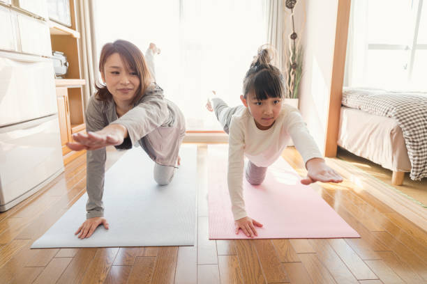 istock Mother and daughter stretching at home 902136994