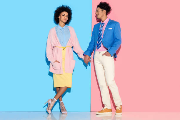 istock girl and guy holding hands on pink and blue background 902141216
