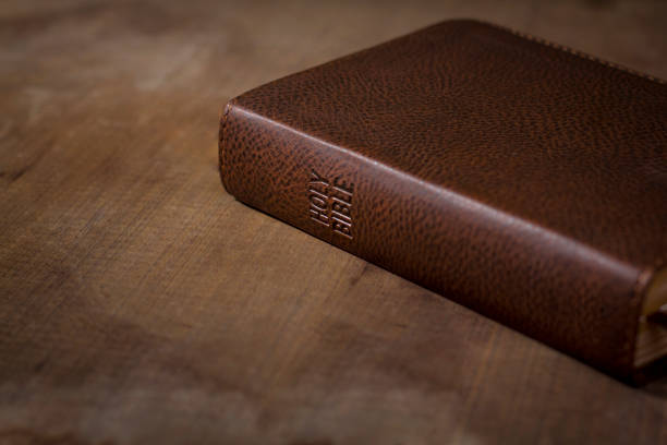 istock Holy Bible laying down closed on wooden table 902141836