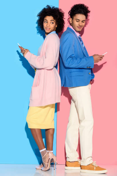 istock couple with phones standing back to back 902144736