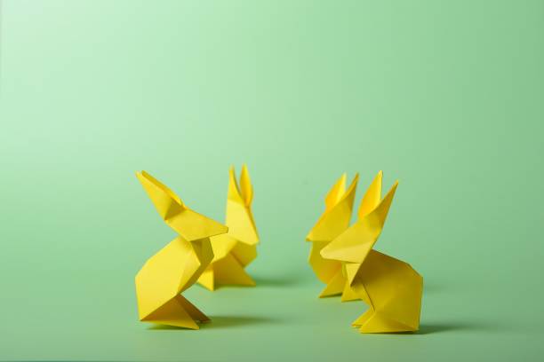 istock Origami paper colorful bunnies on green background. Easter ideas. Space for text. 902145700