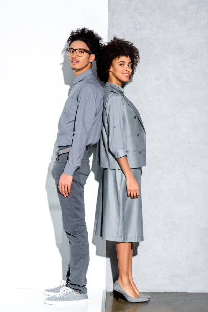 istock couple in grey suits standing back to back 902145716