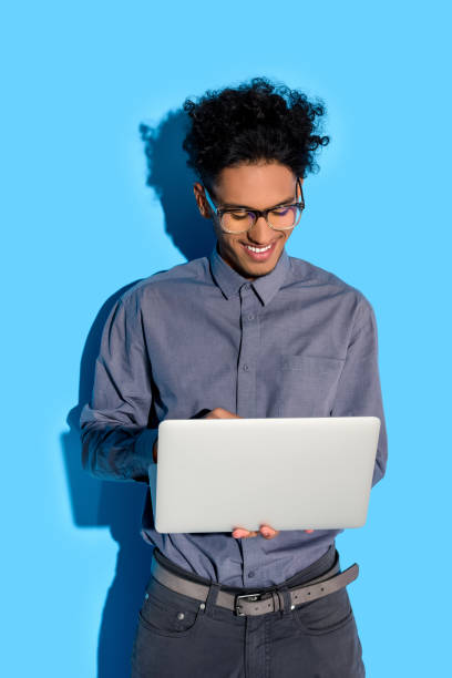 istock businessman looking on laptop screen on blue background 902148474