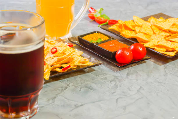 istock Nachos  with Tortilla chips tomato salsa, bean and mustard and two glass with beer on rustic stone background. A texture background.Copy paste place 902152530